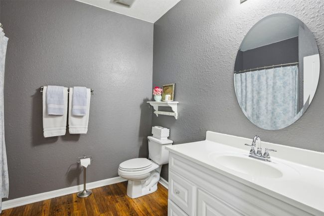 Full Primary bath featuring wood plank laminate flooring, toilet, vanity, baseboards, and visible vents | Image 25