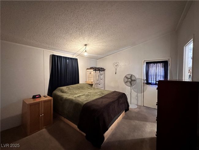 Bedroom with a textured ceiling, carpet flooring, and vaulted ceiling | Image 14