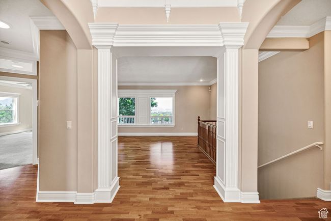 Hall featuring an upstairs landing, healthy amount of natural light, light wood finished floors, and ornamental molding | Image 5