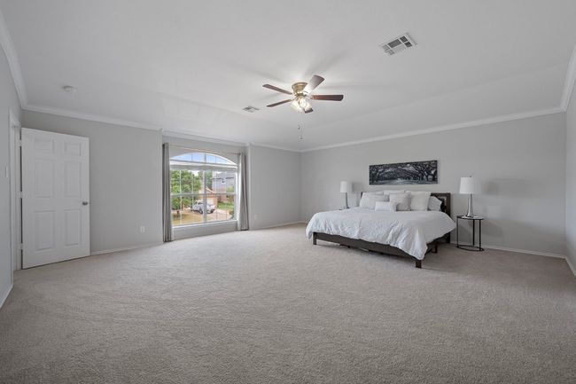 Bedroom with carpet floors, ornamental molding, baseboards, and a ceiling fan | Image 15