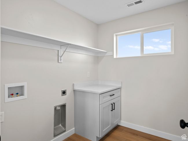 Laundry room with hookup for a washing machine, visible vents, light wood-style floors, electric dryer hookup, and baseboards | Image 17