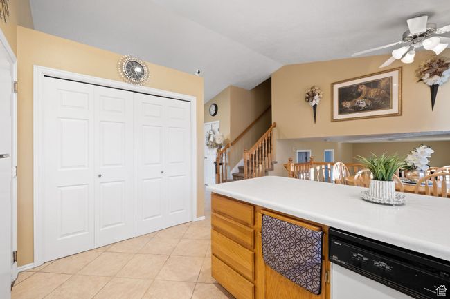 Kitchen with light tile patterned flooring, lofted ceiling, ceiling fan, and white dishwasher | Image 13