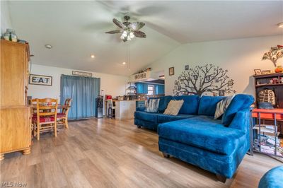 Living room featuring lofted ceiling, light hardwood / wood-style flooring, and ceiling fan | Image 2