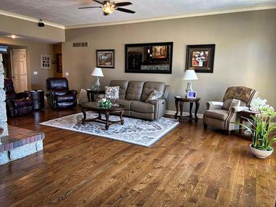 Living room with a textured ceiling, crown molding, ceiling fan, and hardwood / wood-style floors | Image 2