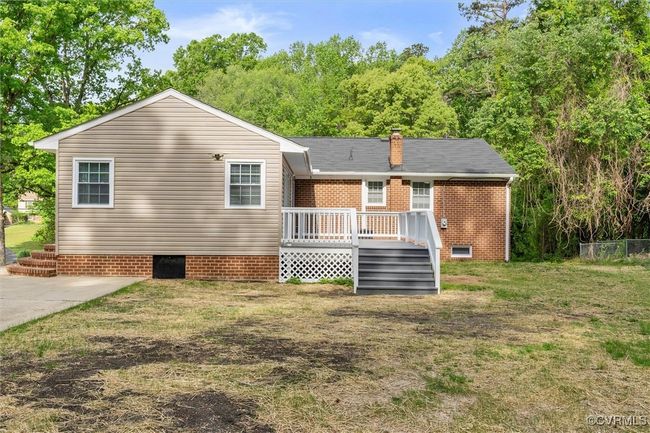 Back of property with a deck, a chimney, brick siding, crawl space, and a lawn | Image 36