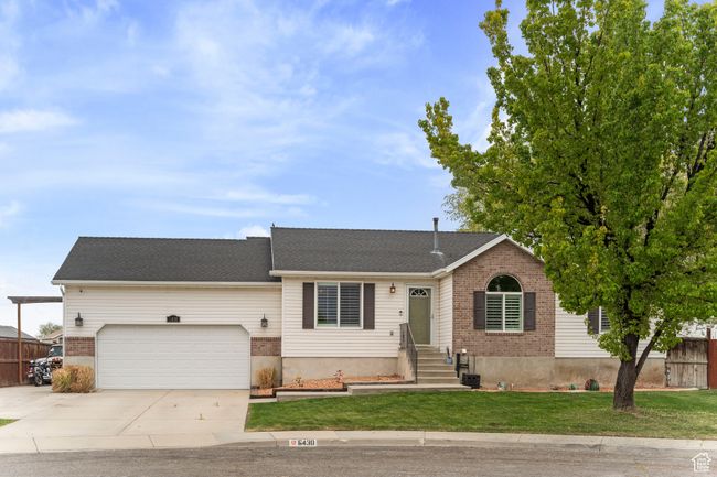 Ranch-style home with concrete driveway, an attached garage, fence, brick siding, and a front lawn | Image 35
