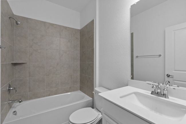 Bathroom with vanity, tub / shower combination, and a textured wall | Image 18