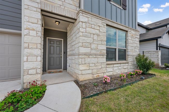 Property entrance featuring board and batten siding and stone siding | Image 4