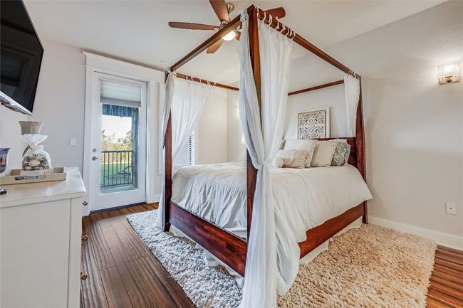 Bedroom featuring baseboards, access to exterior, wood finished floors, and a ceiling fan | Image 11