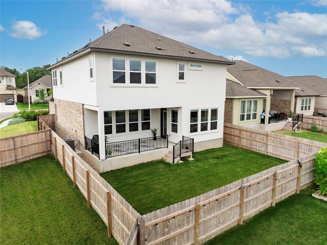 Rear view of property with a fenced backyard, stucco siding, a patio area, and a yard | Image 26