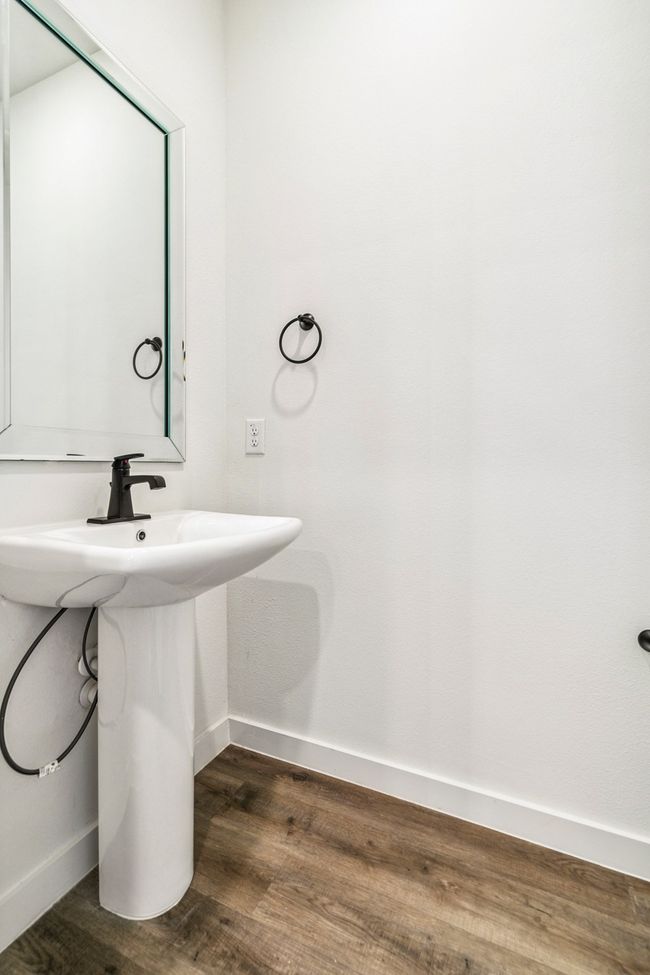 Bathroom with a sink, baseboards, and wood finished floors | Image 17