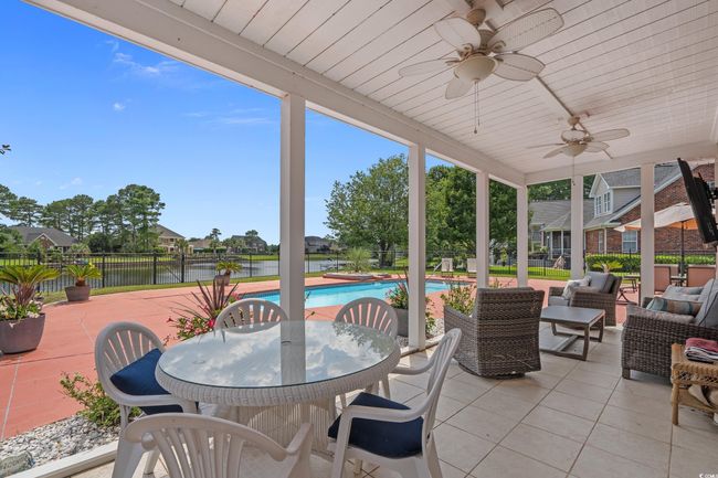 Fenced backyard with a patio, ceiling fan, a water view, outdoor dining area, and outdoor lounge area | Image 15