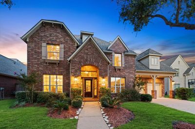 The grand entrance of 6611 Gable Wing Lane welcomes you with meticulously manicured landscaping and a charming driveway. | Image 2