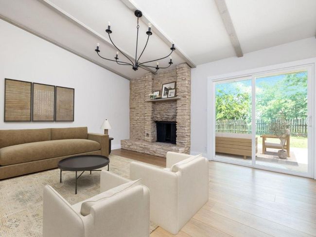 Living room featuring a chandelier, light wood finished floors, and a fireplace | Image 10