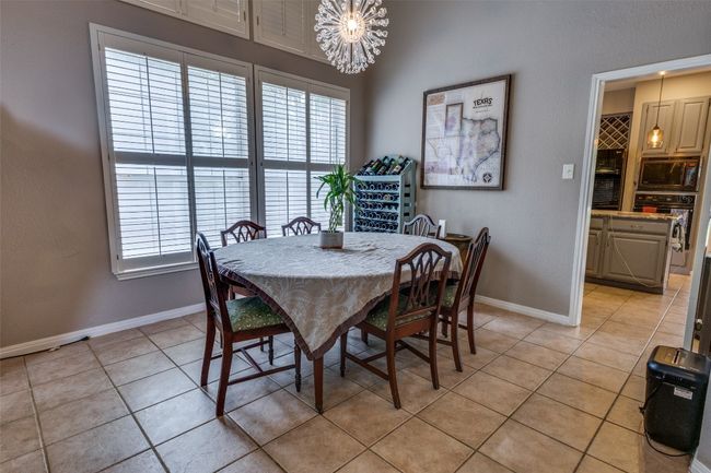 Open concept with two dining areas and entry to kitchen with second dining area & second living area with fireplace. | Image 6