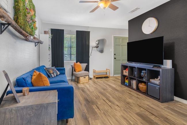 Living room with a ceiling fan, wood finished floors, and baseboards | Image 6