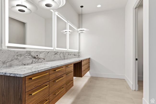Bathroom with decorative backsplash, baseboards, a sink, and double vanity | Image 38