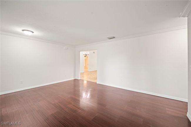 Unfurnished room with ornamental molding, a chandelier, and wood finished floors | Image 8