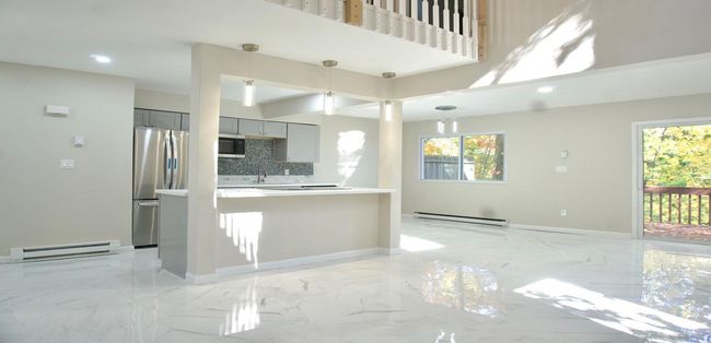 Kitchen with a baseboard heating unit, gray cabinetry, marble finish floor, and appliances with stainless steel finishes | Image 36