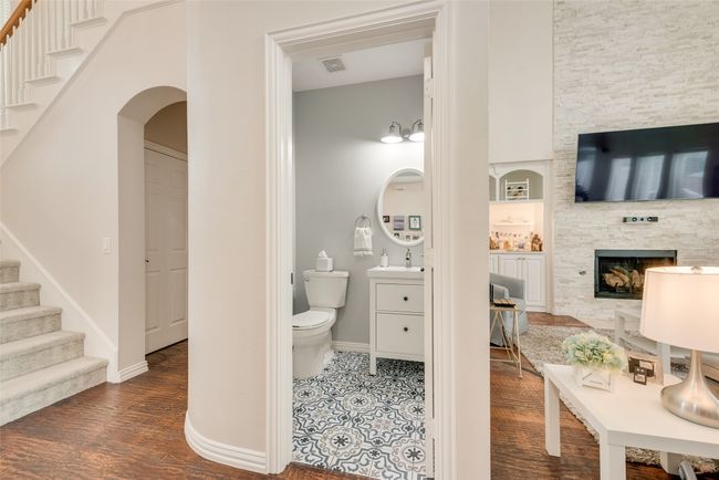 Bathroom featuring toilet, vanity, baseboards, wood finished floors, and built in shelves | Image 4