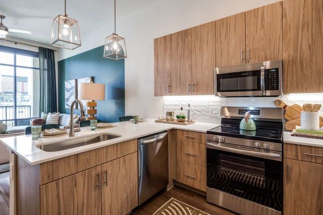 Kitchen with pendant lighting, sink, appliances with stainless steel finishes, backsplash, and kitchen peninsula | Image 7
