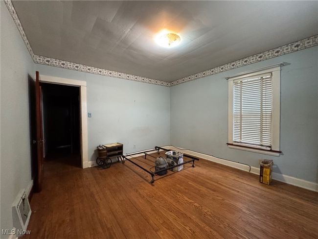 Empty room featuring baseboards, visible vents, and wood finished floors | Image 17