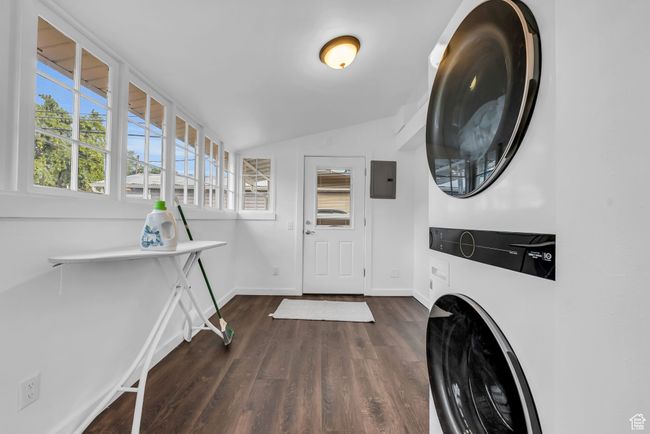 Laundry room with stacked washer / dryer, dark wood finished floors, baseboards, and electric panel | Image 14