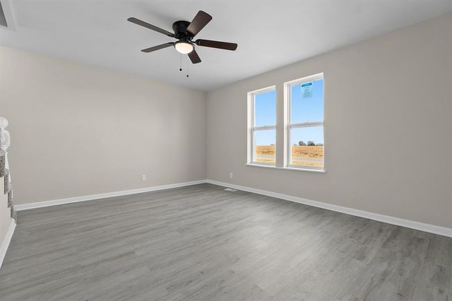 Spare room with wood finished floors, baseboards, and ceiling fan | Image 9