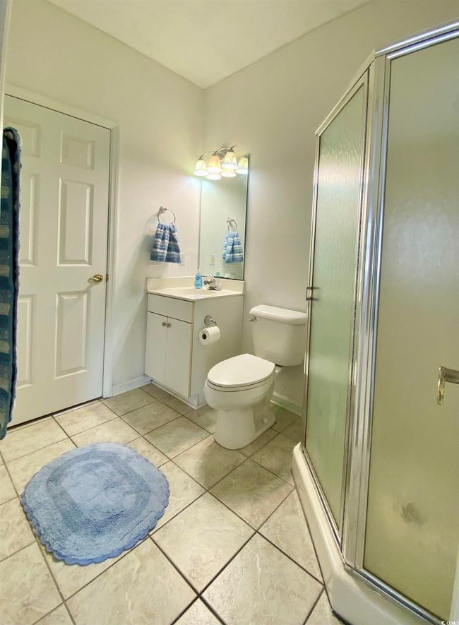 Full bath featuring vanity, toilet, baseboards, a shower stall, and tile patterned floors | Image 13