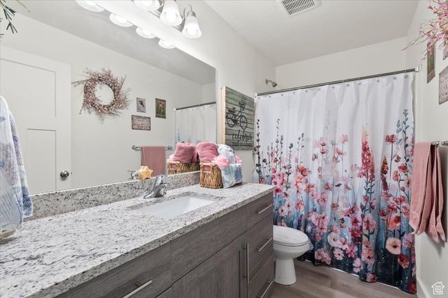 Full bath featuring wood finished floors, vanity, toilet, and a shower with shower curtain | Image 23