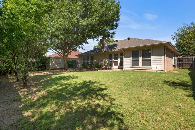 Rear view of property featuring wooden privacy fence and shaded lot | Image 22