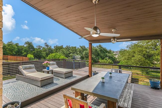 Expansive back deck with multiple seating areas, a dining area and a built in grill. Backyard backs to a privatr 'green space'. | Image 14