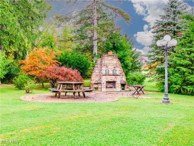 View of yard featuring an outdoor stone fireplace | Image 2