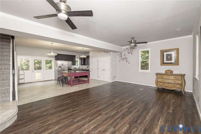 Living area featuring stairway, ornamental molding, a ceiling fan, light wood-style floors, and french doors | Image 33