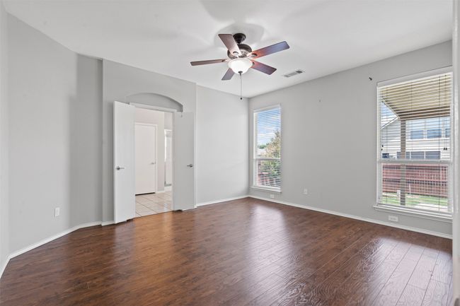 Unfurnished room with wood finished floors, ceiling fan, and arched walkways | Image 11
