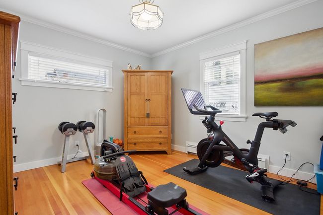 Exercise room featuring light wood finished floors, crown molding, and baseboards | Image 14