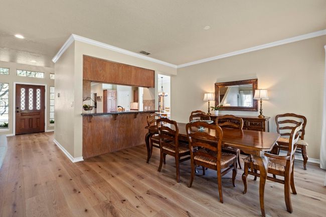 Dining area featuring visible vents, light wood-style flooring, baseboards, and ornamental molding | Image 8