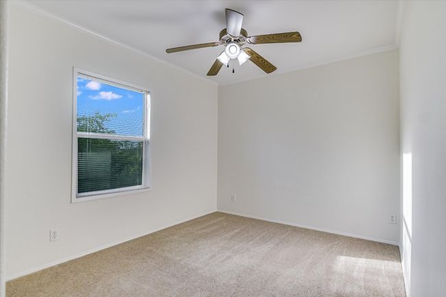 Bedroom 2 has private views out the back, a closet, and ceiling fan | Image 15