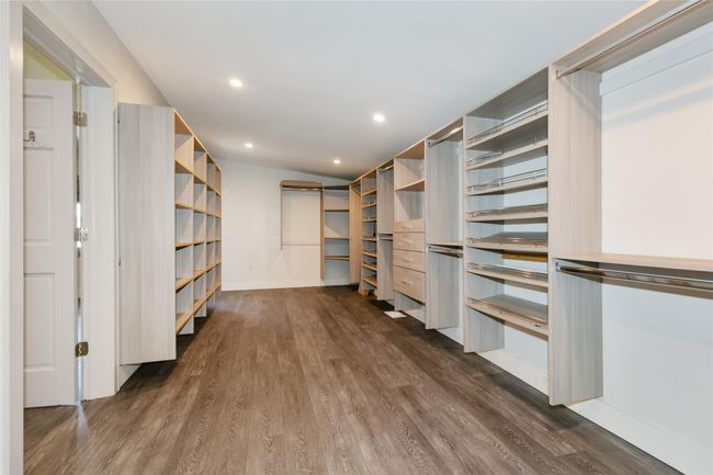 Walk in closet featuring dark wood-type flooring | Image 16