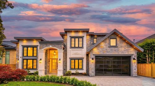 Stone veneer and stucco exterior with a prominent arched entry | Card Image