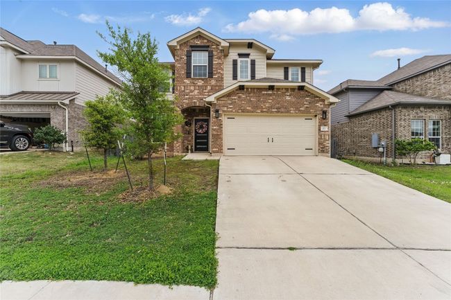 Traditional-style home featuring driveway, a front yard, a garage, and brick siding | Image 39