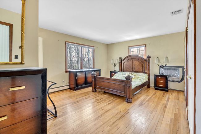 Bedroom featuring baseboards, visible vents, light wood-style floors, and a baseboard radiator | Image 13