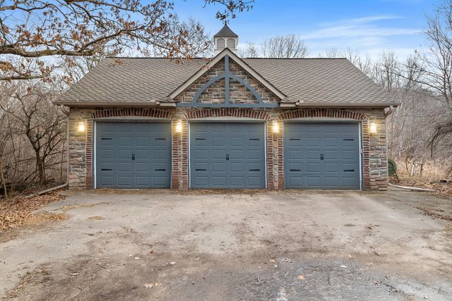 Three stalls of the detached garage have extra-high doors for storage of taller vehicles and recreational equipment. | Image 76