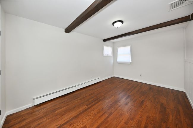 Spare room featuring beamed ceiling, visible vents, a baseboard heating unit, baseboards, and dark wood-type flooring | Image 16