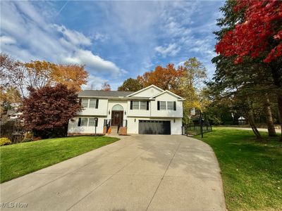 Split foyer home featuring a front yard and a garage | Image 1