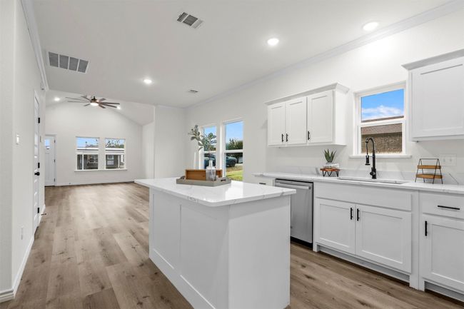 Kitchen featuring dishwasher, light hardwood / wood-style floors, a center island, sink, and white cabinetry | Image 15