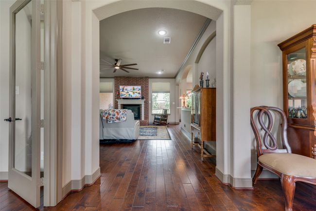 Hall featuring arched walkways, dark wood finished floors, and crown molding | Image 11