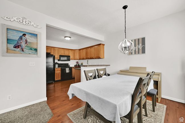 Dining room with beam ceiling, baseboards, an inviting chandelier, and dark wood finished floors | Image 26