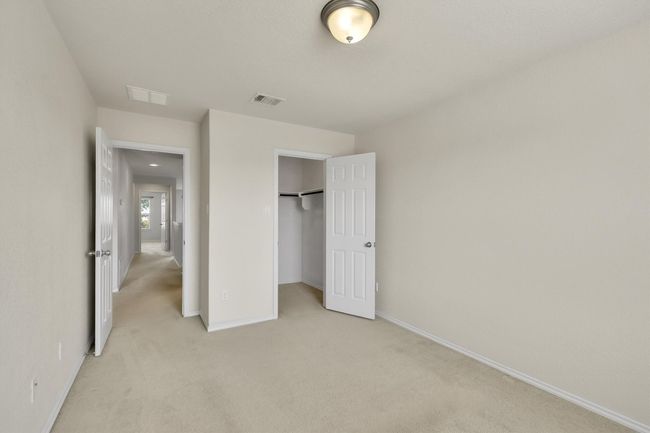 Unfurnished bedroom featuring light carpet, baseboards, visible vents, and a closet | Image 17