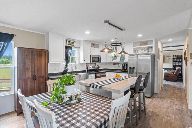 Dining area with light wood-style floors, recessed lighting, crown molding, and a textured ceiling | Image 11
